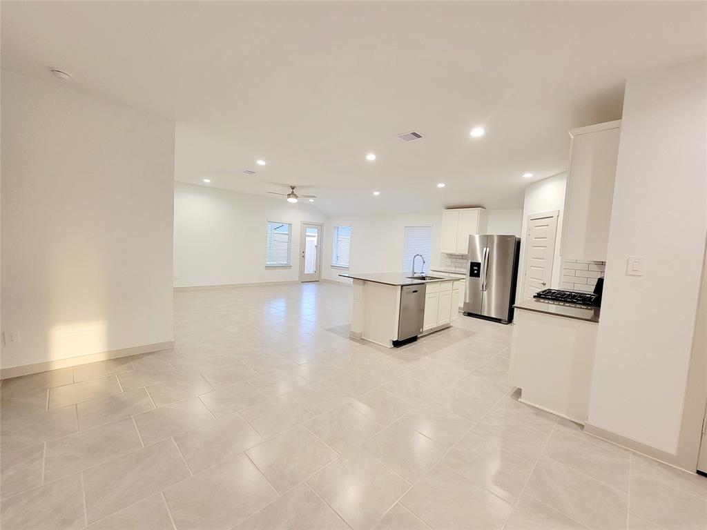 a view of an empty room with a kitchen