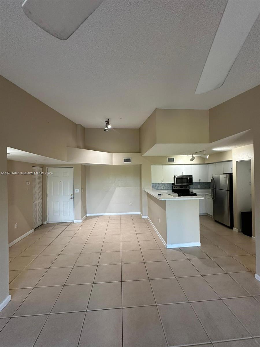 a large white kitchen with a sink and dishwasher a stove top oven with wooden floor