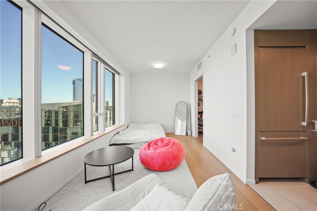 a bedroom with a bed and large windows