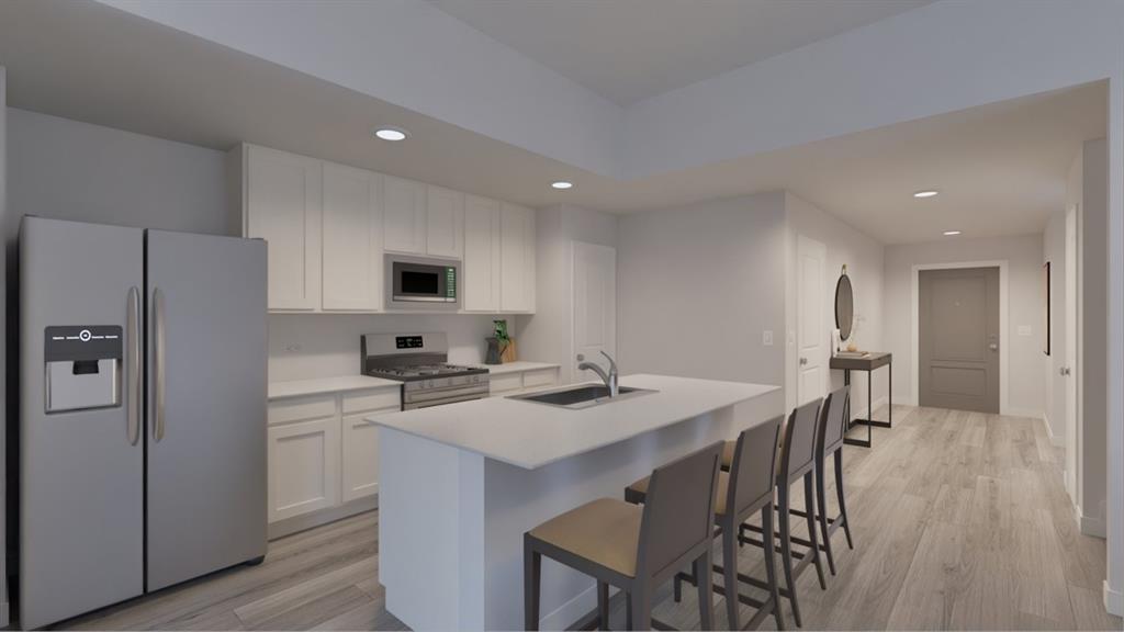 a kitchen with a table chairs refrigerator and microwave