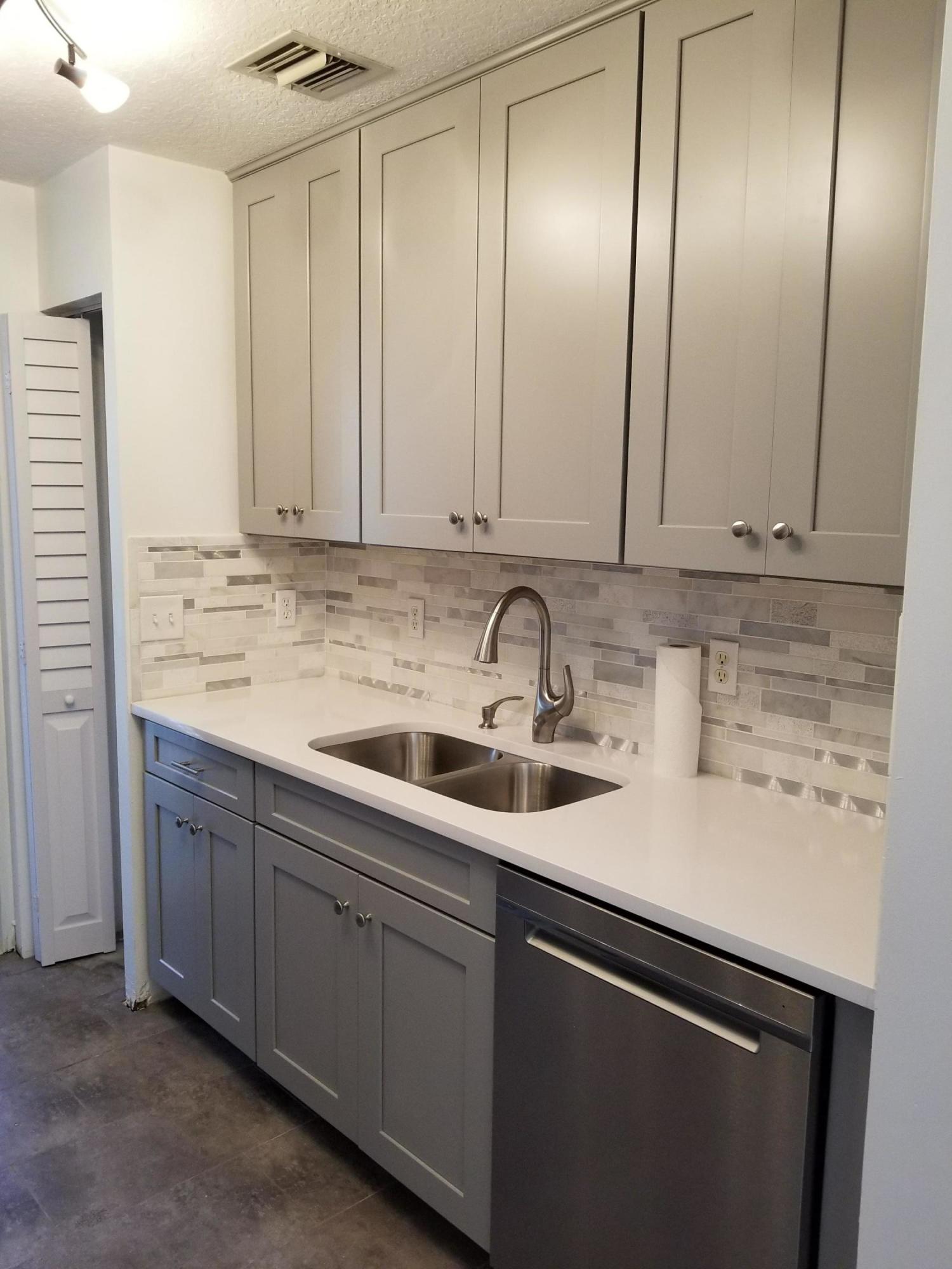 a kitchen with stainless steel appliances granite countertop white cabinets and sink