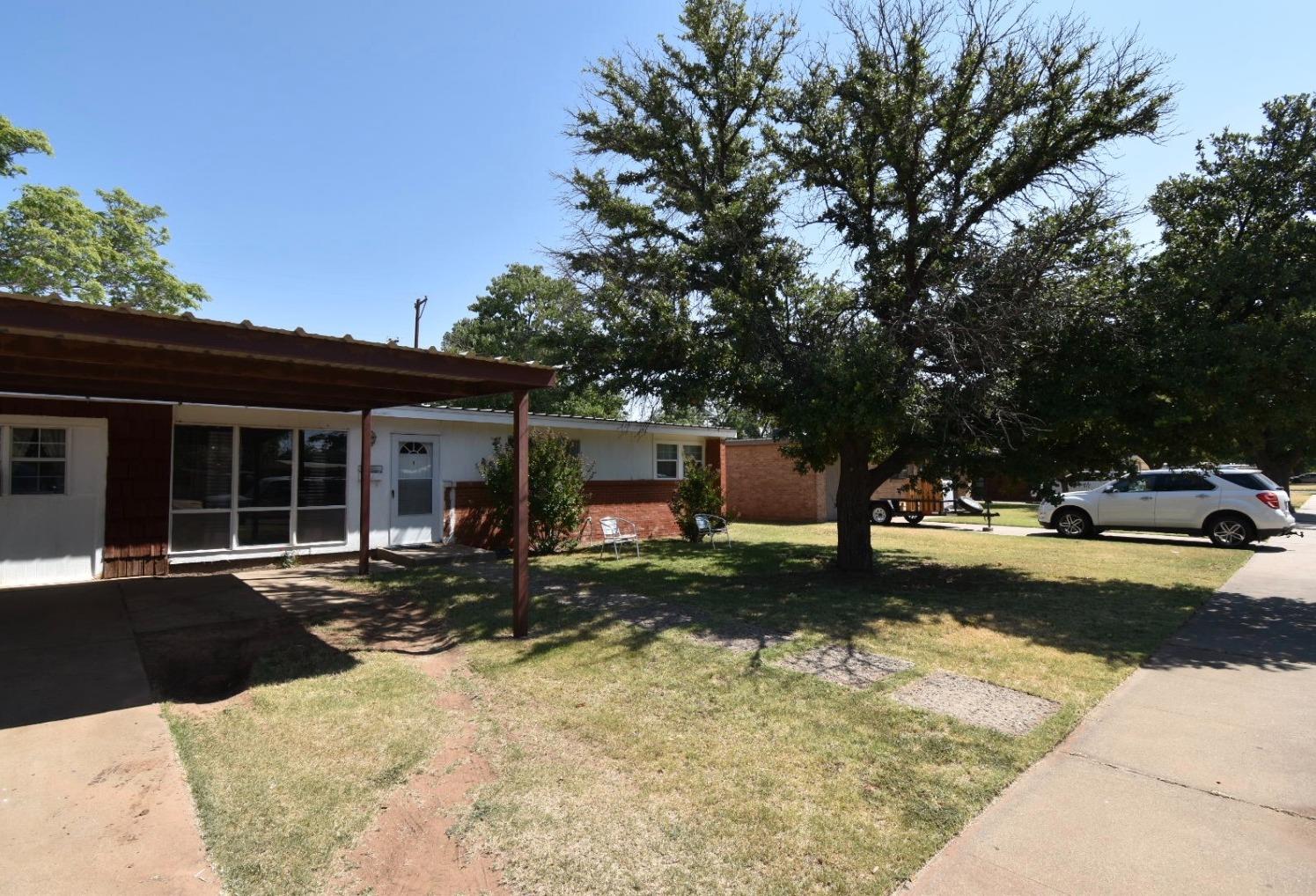 a front view of a house with a yard and trees