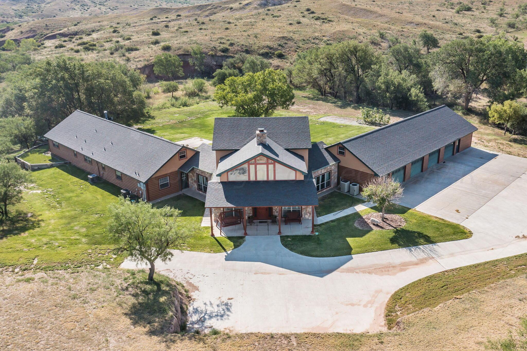 an aerial view of a house with a garden and lake view