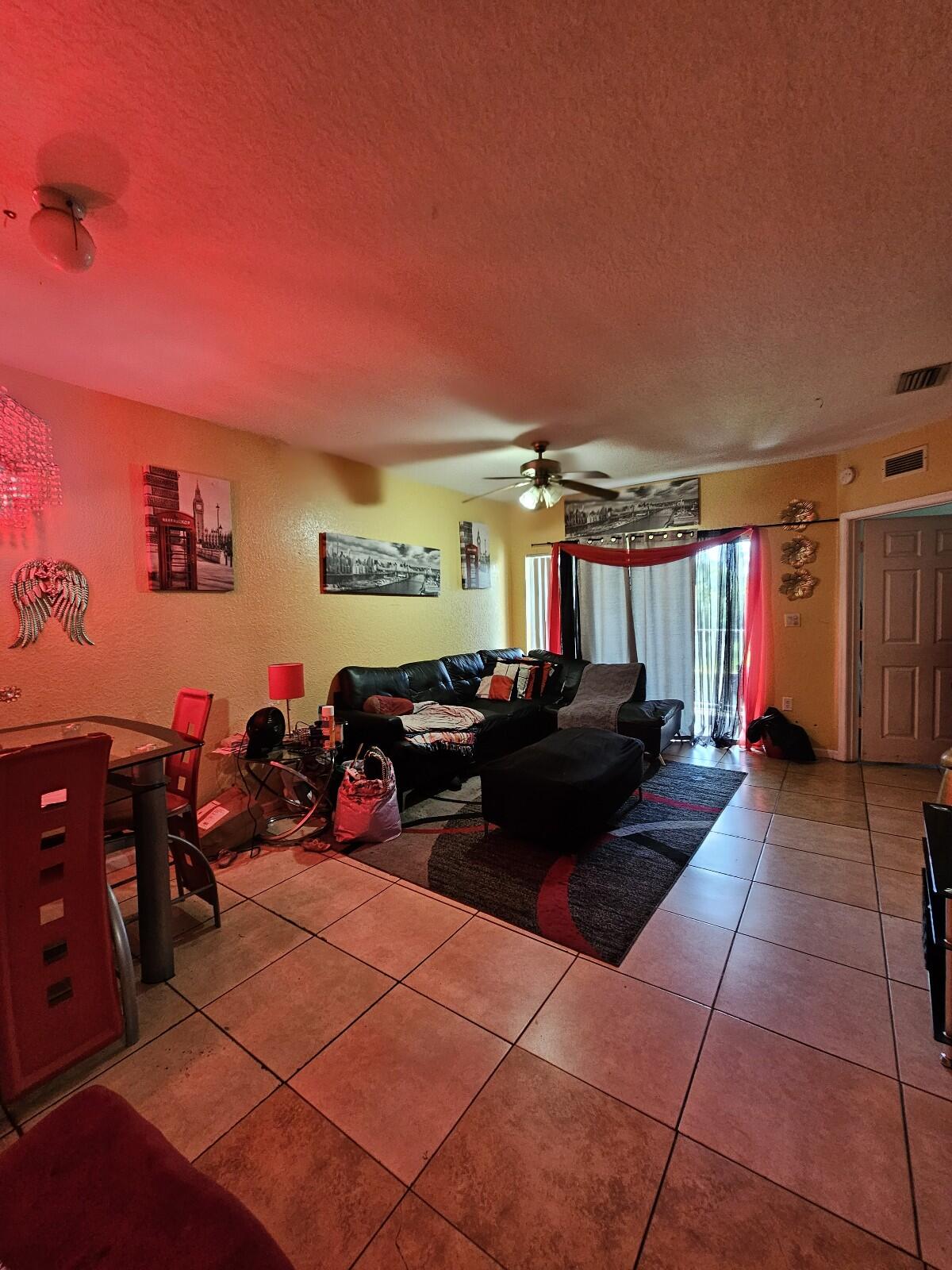 a living room with furniture a flat screen tv and gym equipment