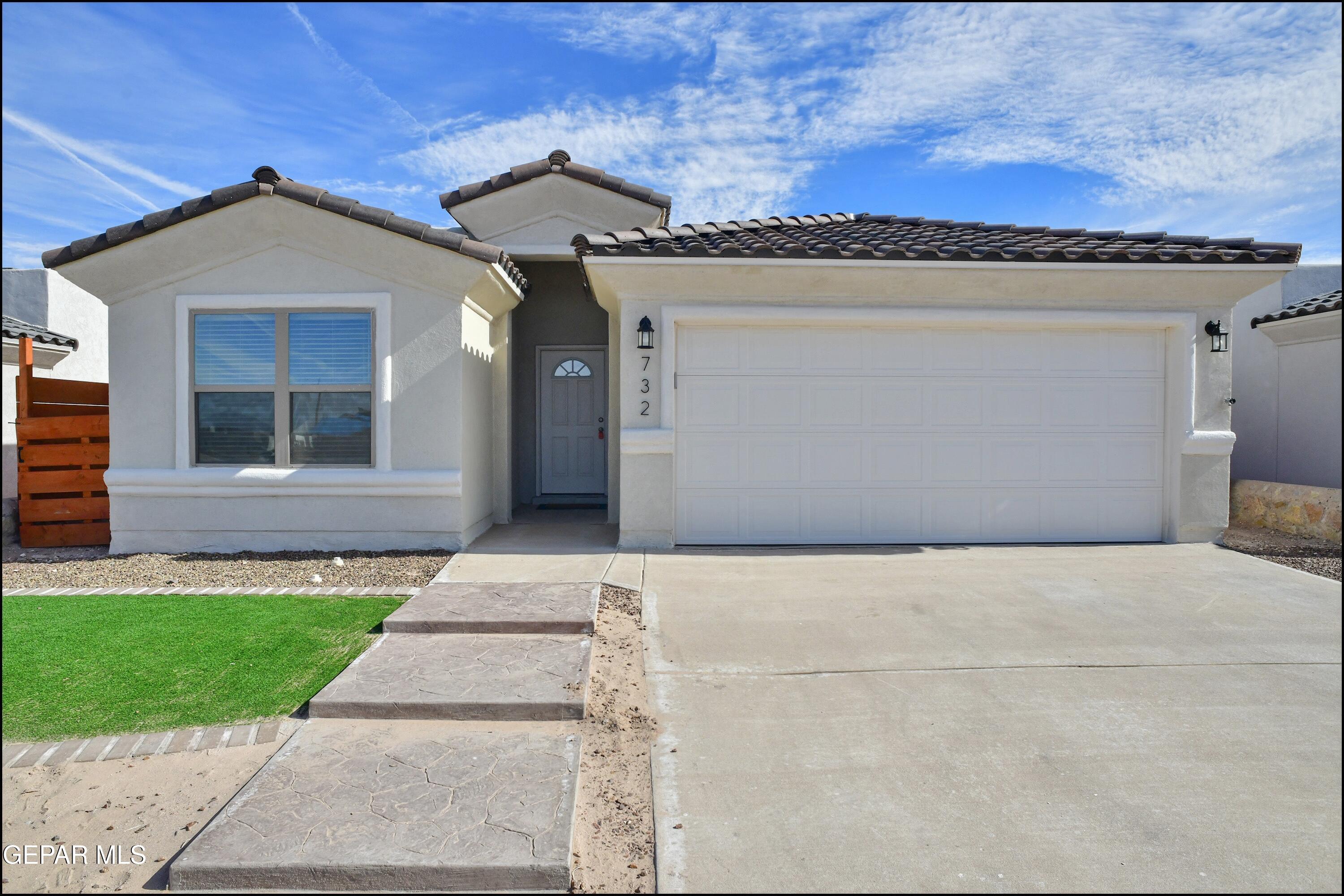 a front view of a house with a yard and garage