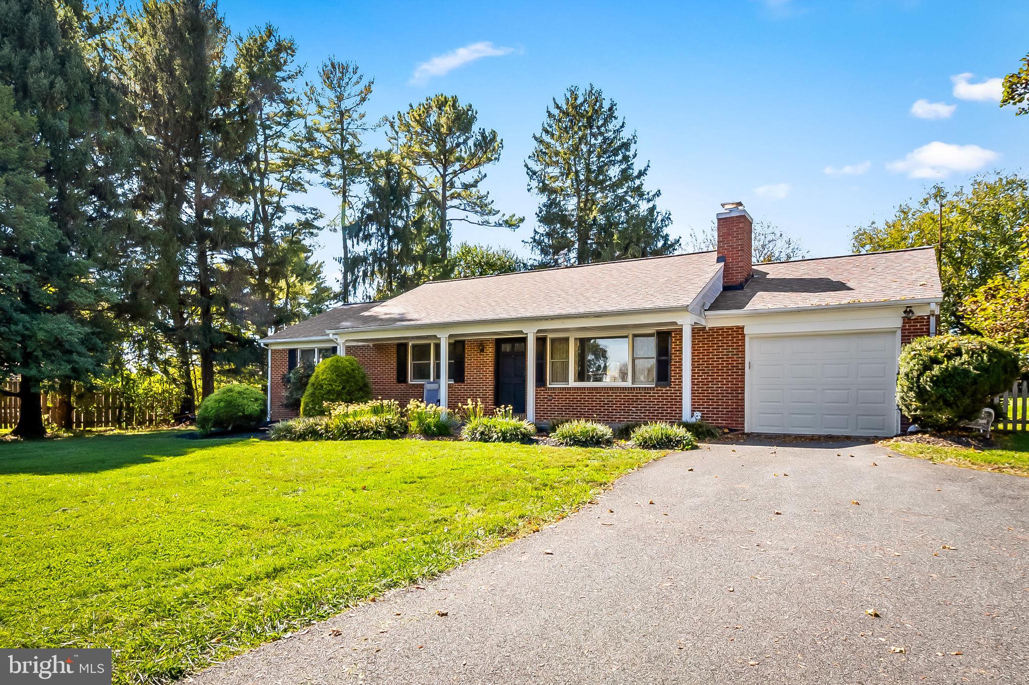 a front view of a house with yard and green space