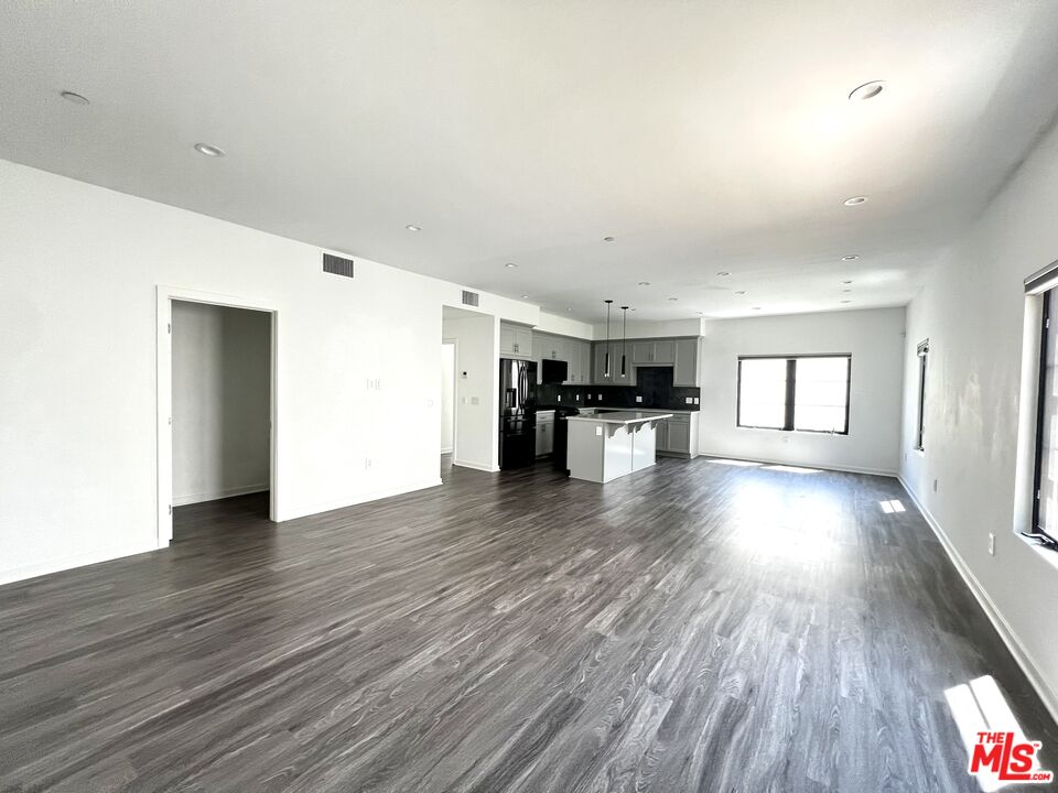 a view of empty room with wooden floor and fireplace