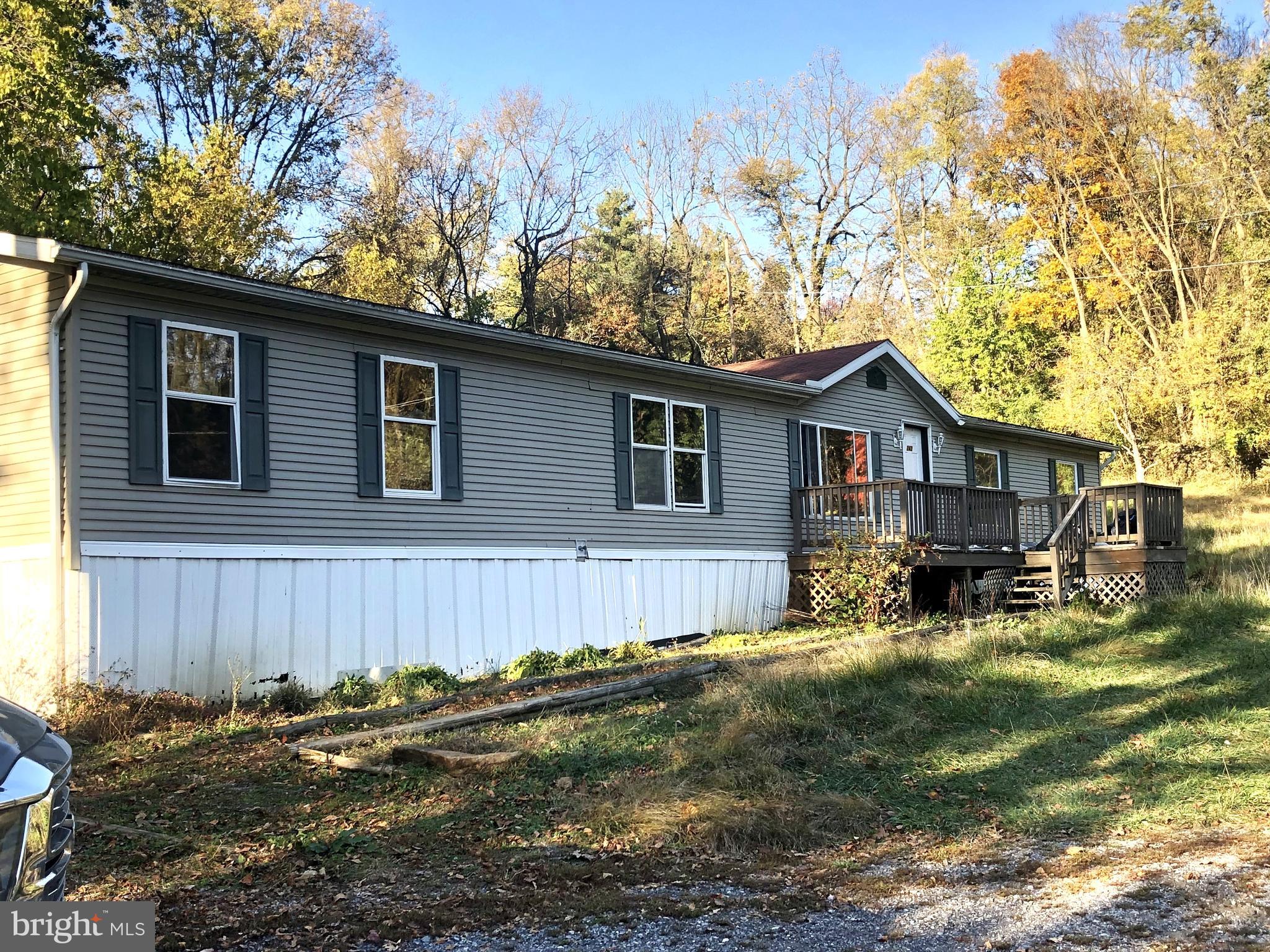 a view of a house with a yard chairs and wooden fence