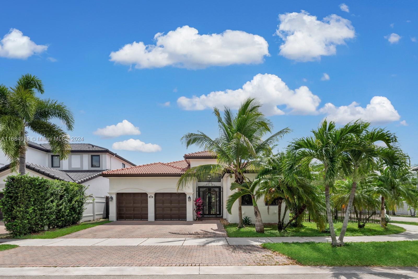 a front view of a house with a yard and a garden