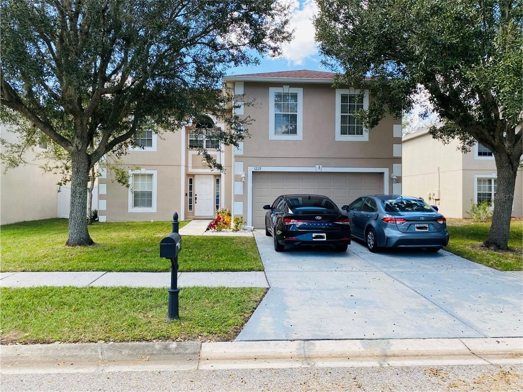 a couple of cars parked in front of a house