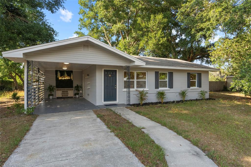 a front view of house with yard and trees in the background