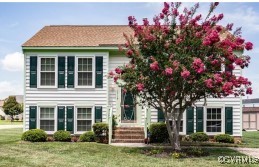 a front view of a house with a tree