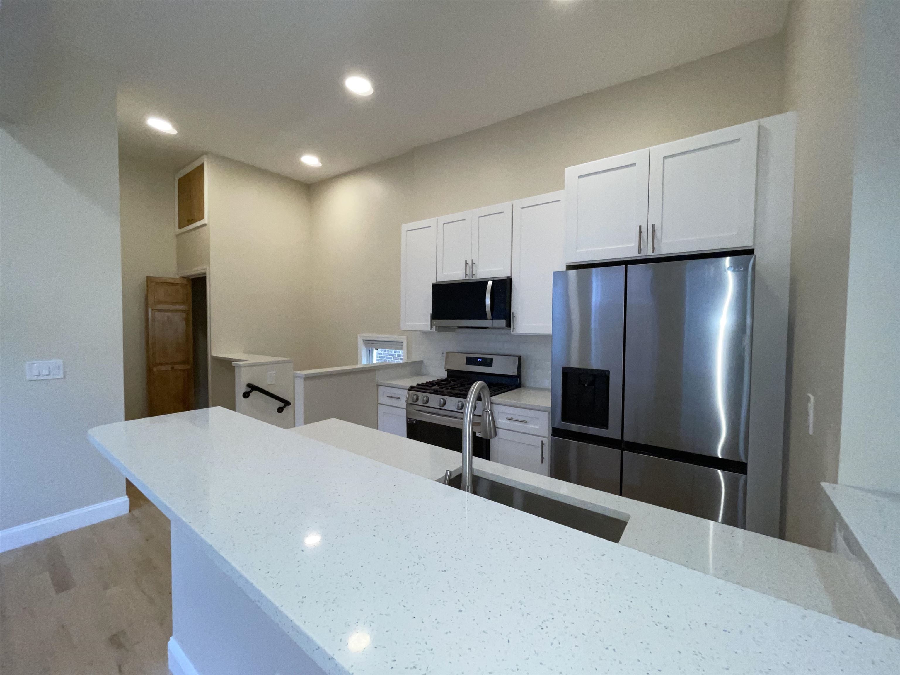 a kitchen with stainless steel appliances a refrigerator and a stove top oven