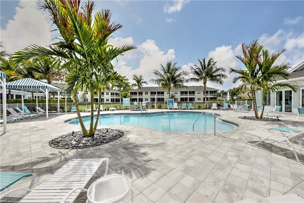 a view of a swimming pool with a patio and palm trees