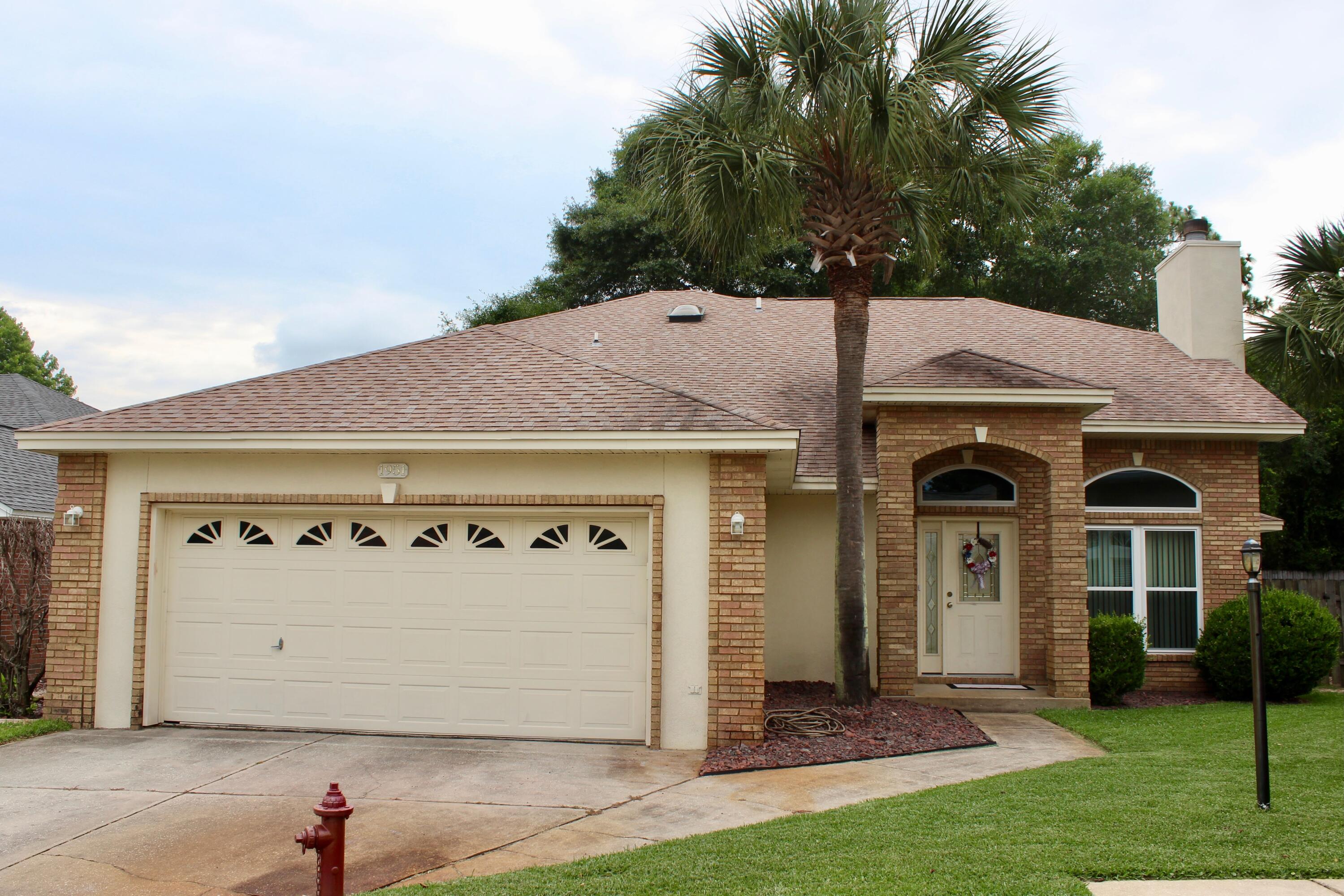 a front view of a house with a garden and garage