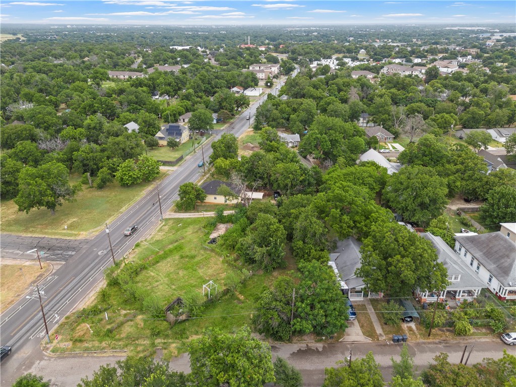 an aerial view of residential houses with outdoor space and trees