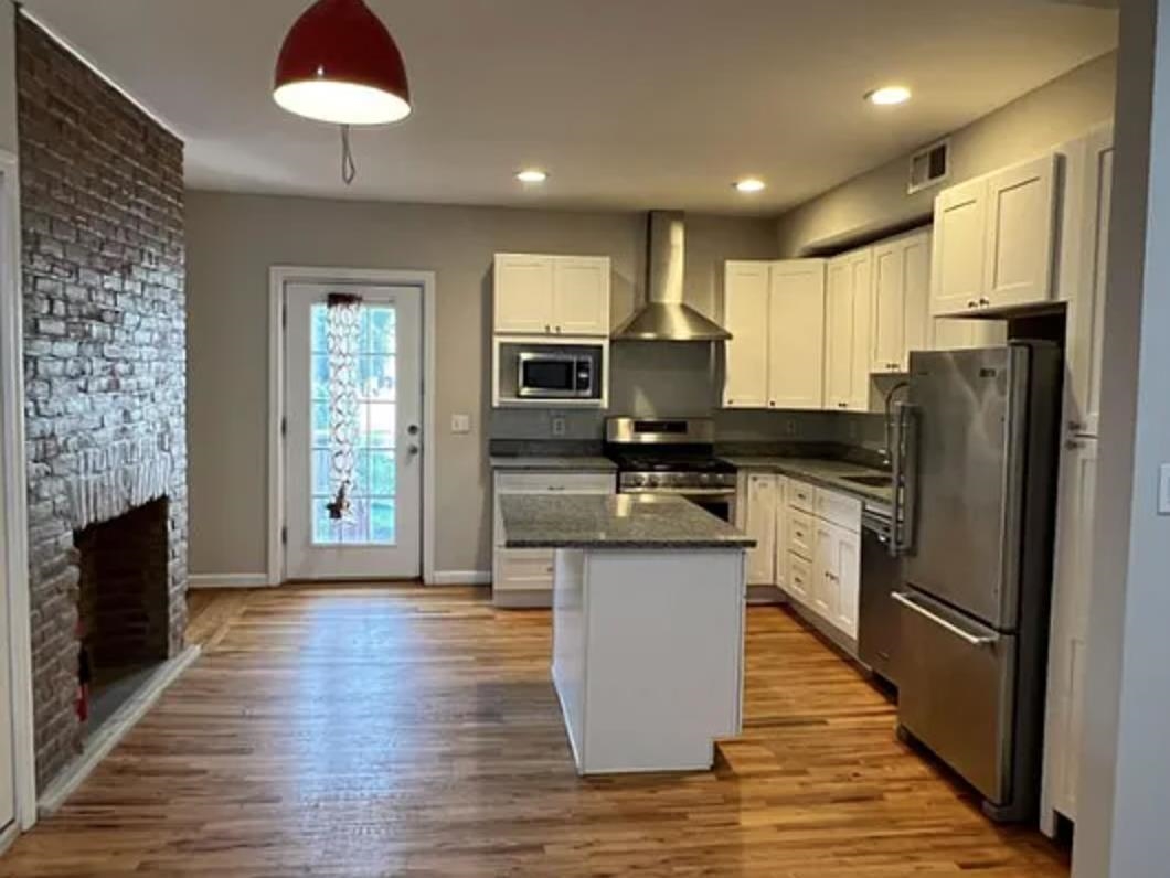 a kitchen with stainless steel appliances granite countertop a refrigerator stove microwave and sink