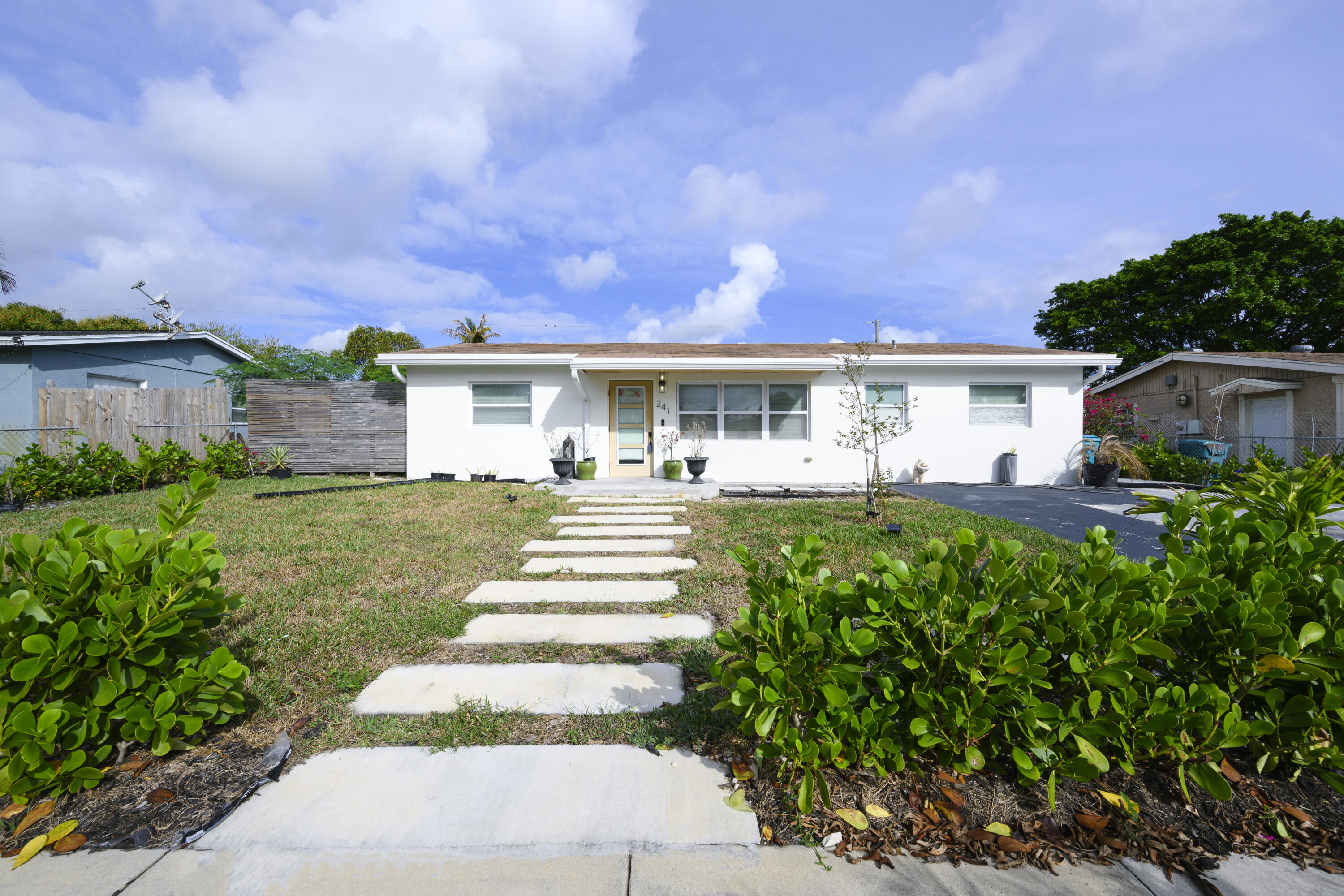 a front view of a house with a yard garden and outdoor seating