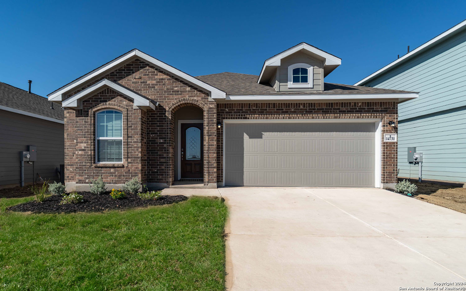 a front view of a house with a yard and garage