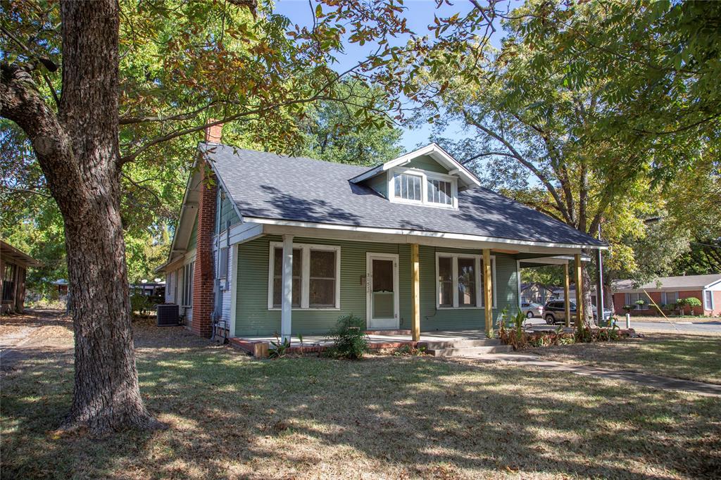 a front view of a house with a garden and trees