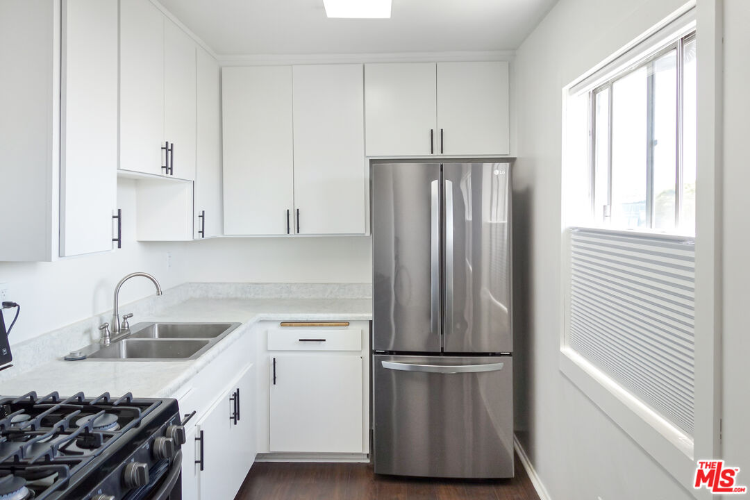 a kitchen with a refrigerator sink and cabinets