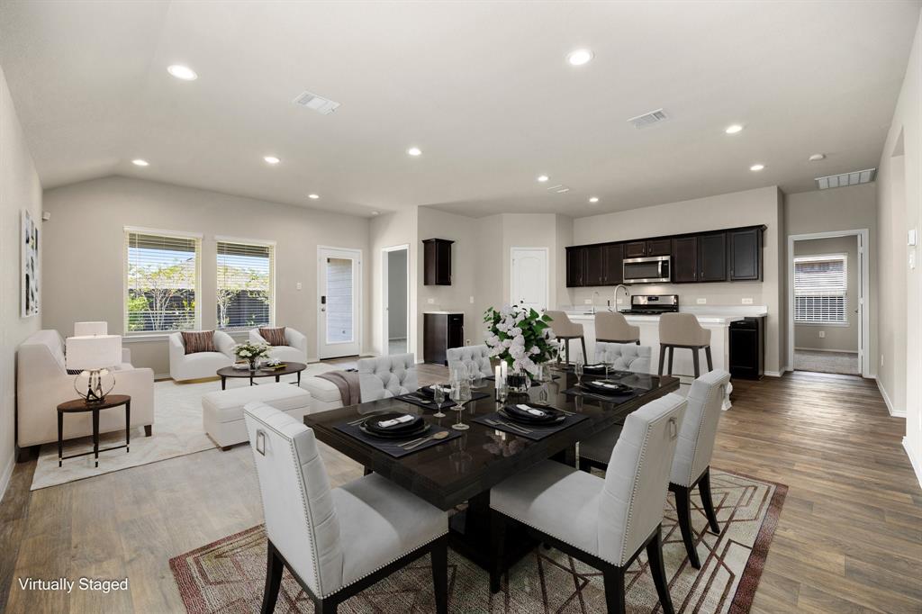 a view of a dining room with furniture a rug and wooden floor