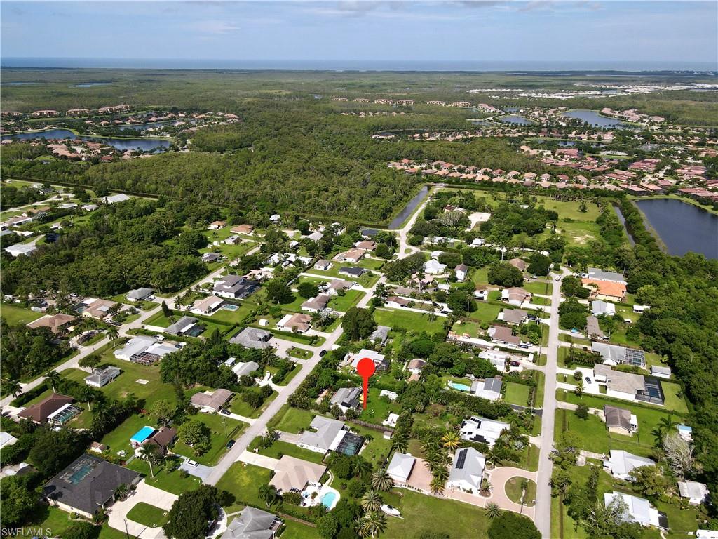 an aerial view of residential houses with outdoor space and trees