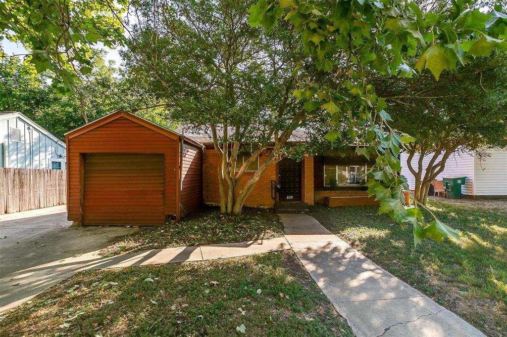 a front view of a house with a yard and tree