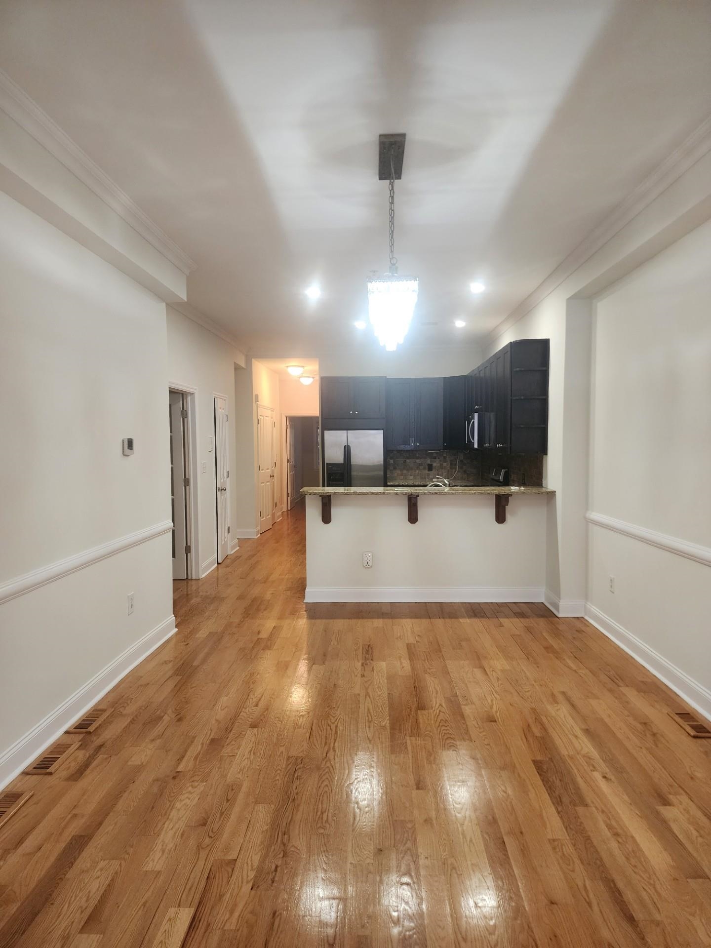 a view of a kitchen with a sink and a refrigerator