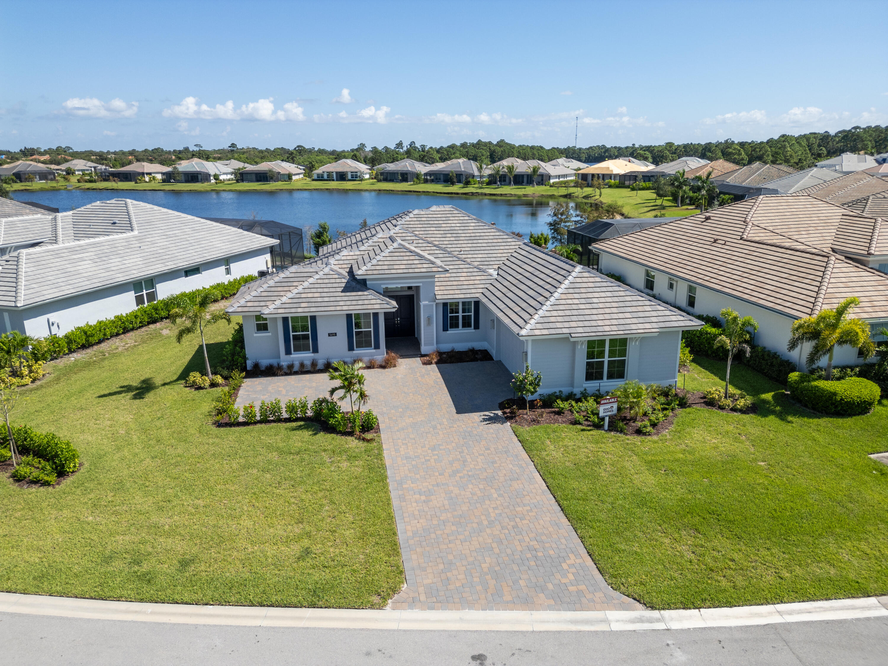 an aerial view of a house with yard lake and outdoor seating