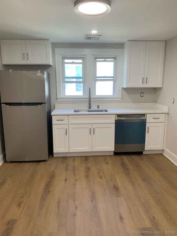 a view of a kitchen with sink and refrigerator