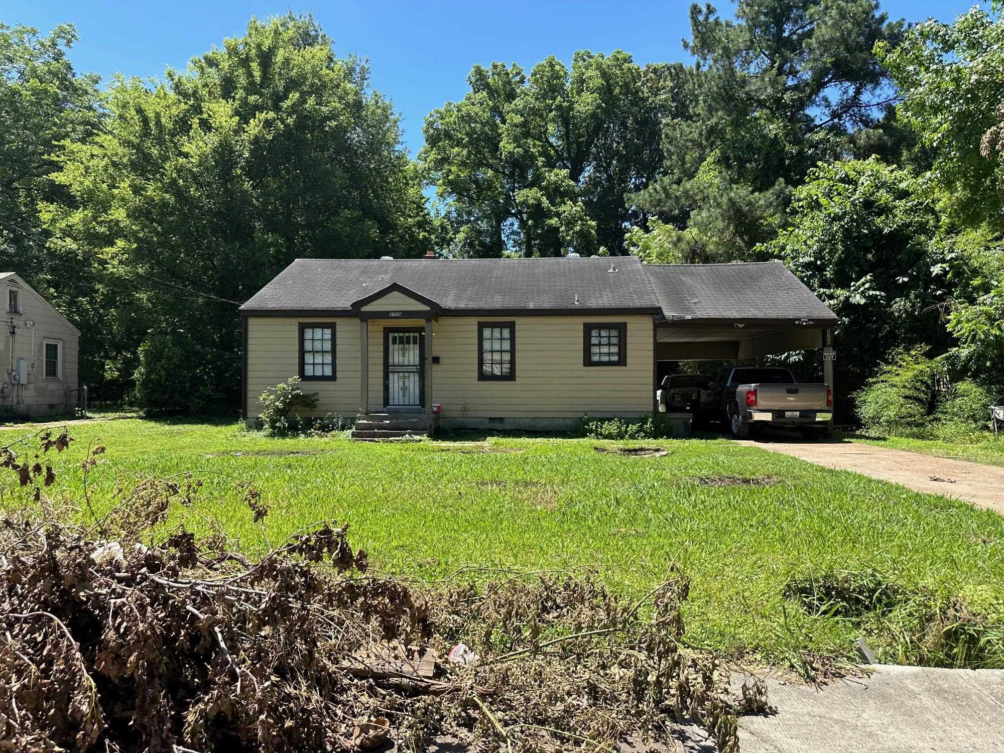 a front view of a house with a yard and trees