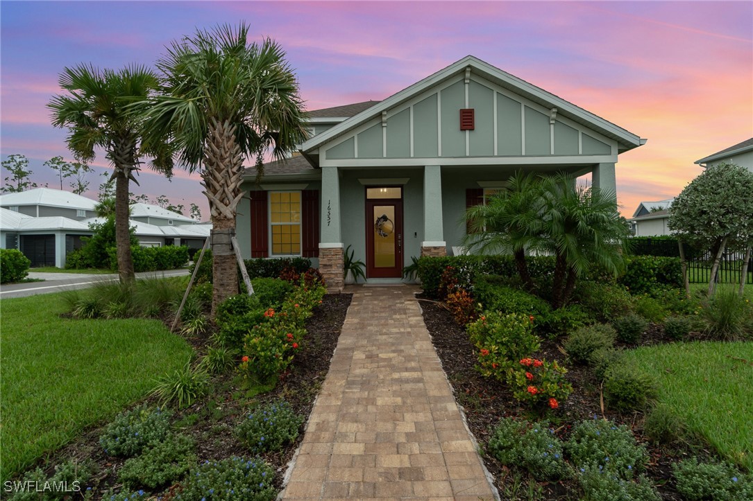 a front view of a house with a yard and potted plants