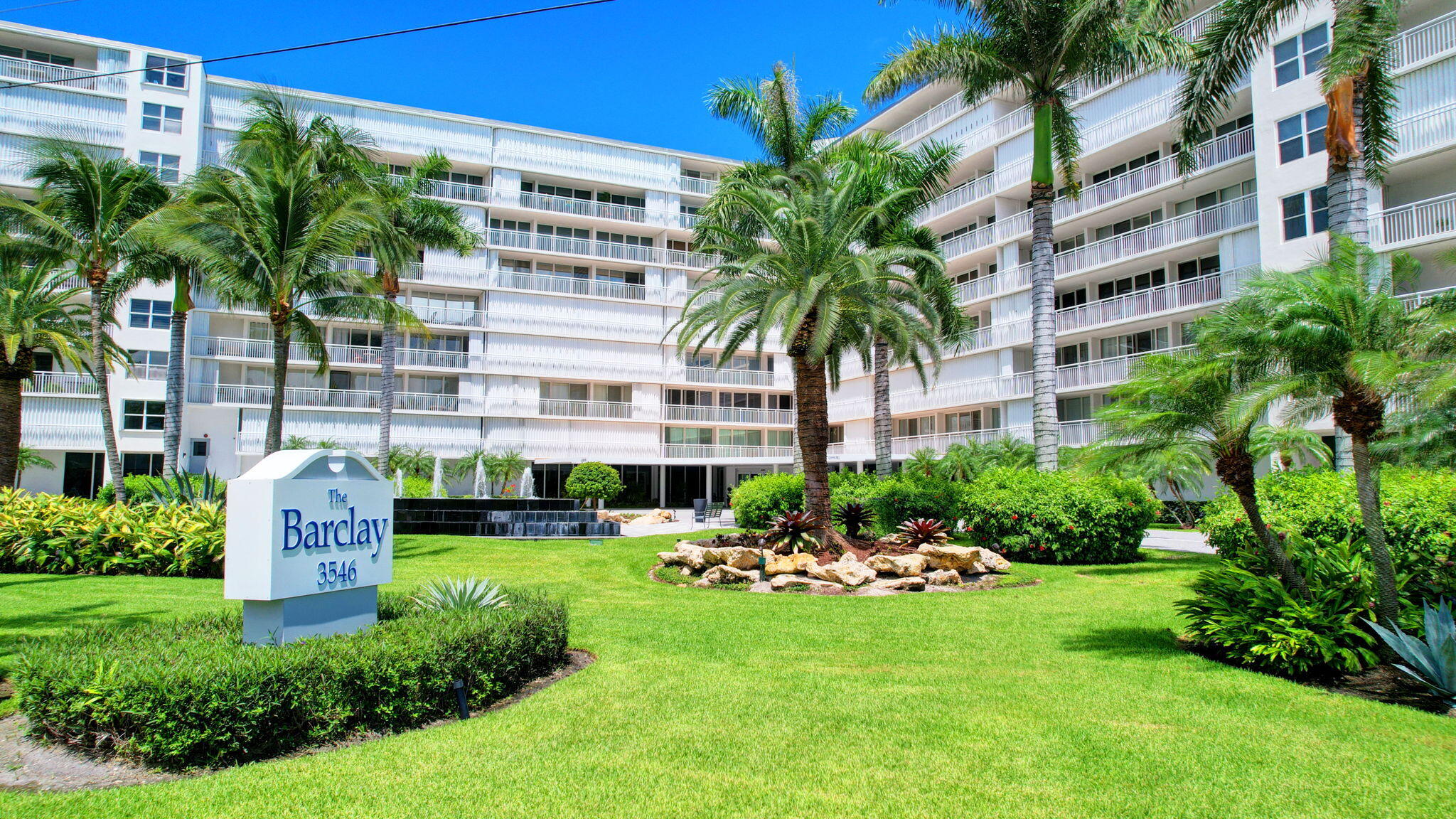 a garden with tall buildings in the background