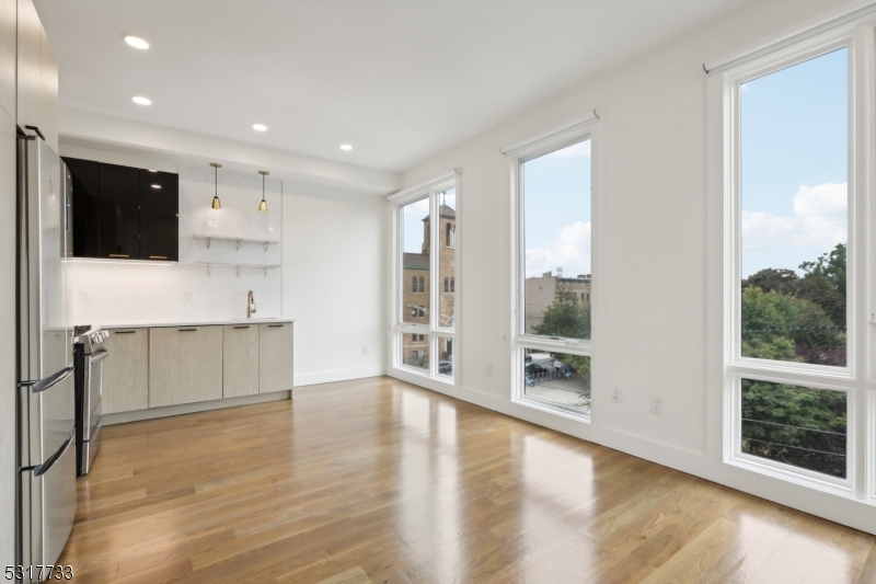 a view of an empty room with a kitchen and a window