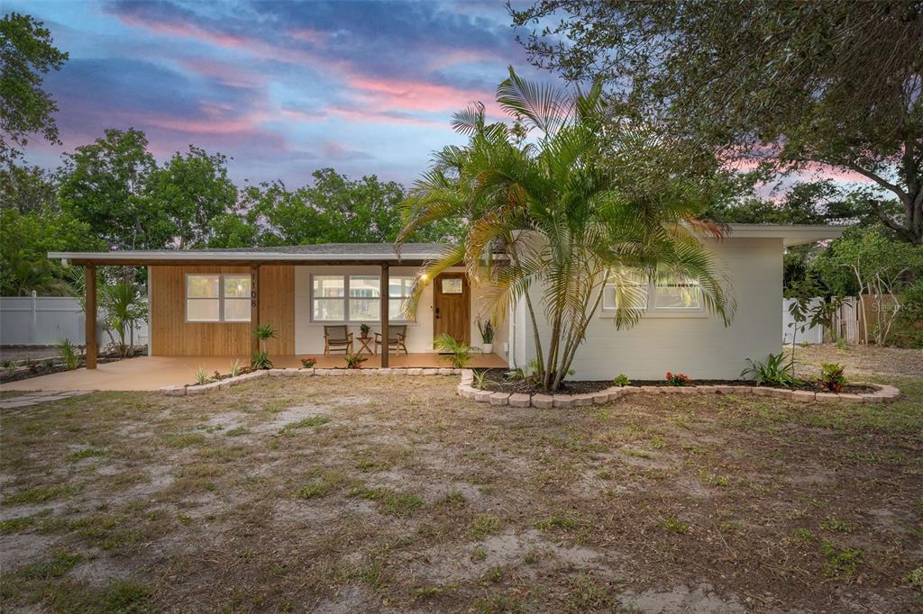 a view of a house with a tree and a yard