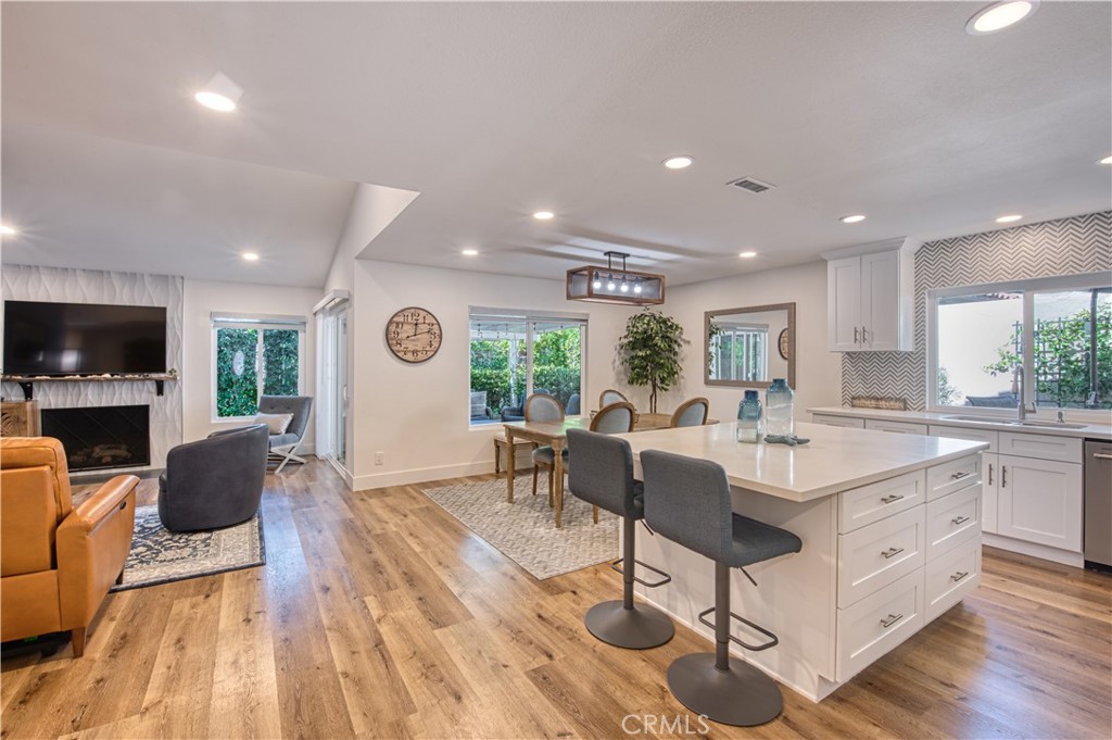 a living room with furniture a flat screen tv and kitchen view