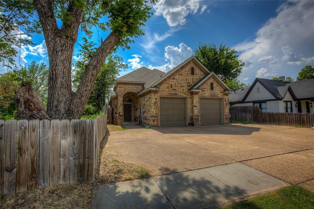 a front view of a house with a yard and trees