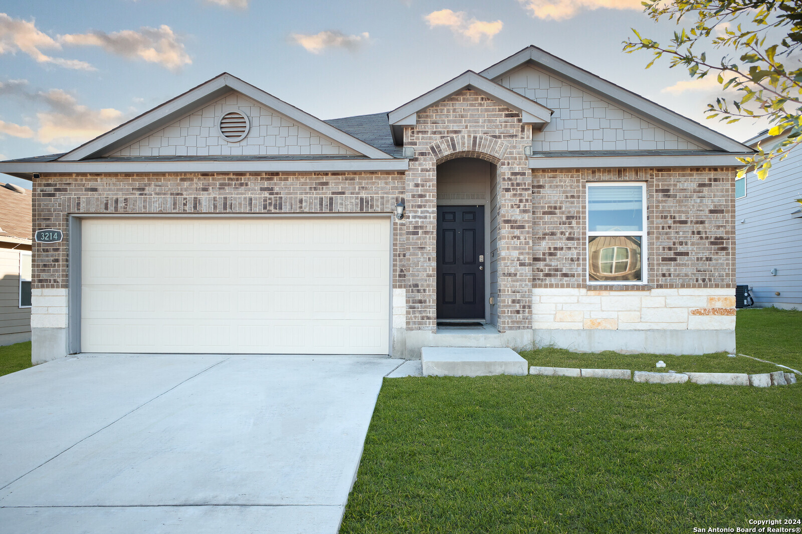 a front view of a house with a yard and garage