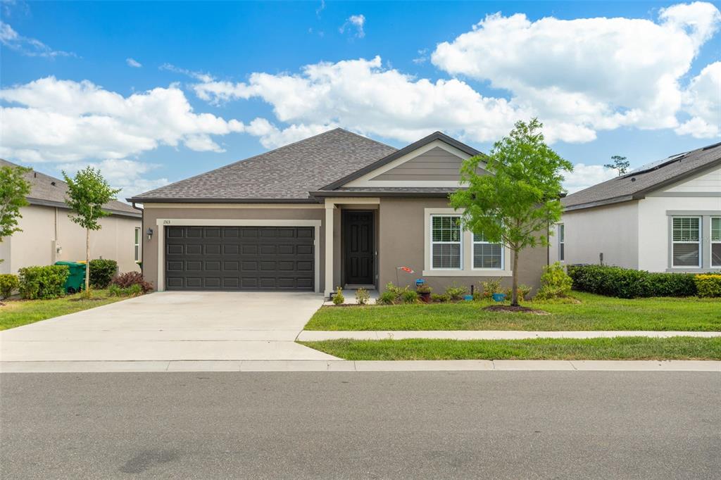 a front view of a house with a yard and garage