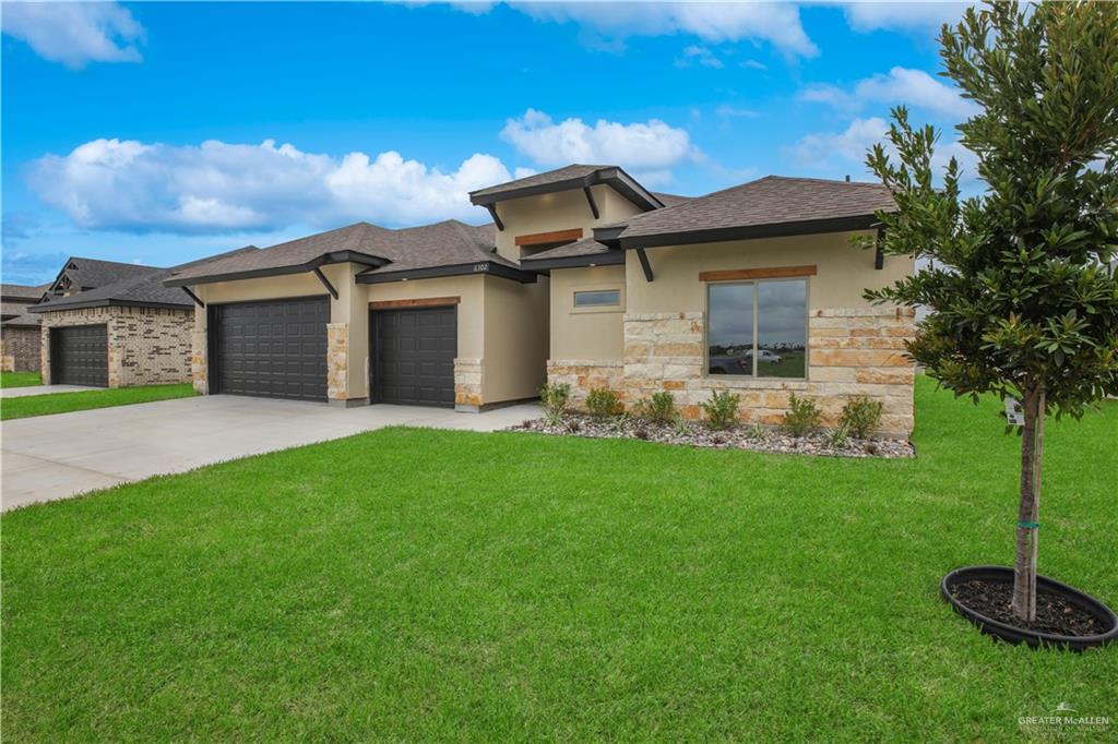 Prairie-style house featuring a garage and a front yard