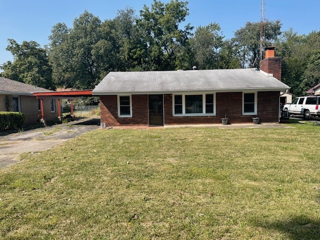 a view of a house with a yard and sitting area