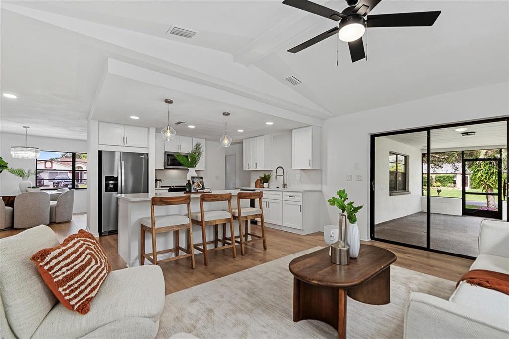 a living room with furniture and a view of kitchen