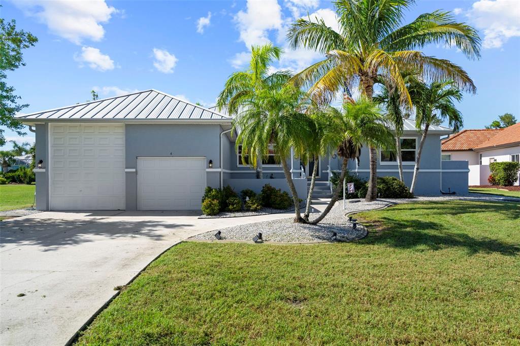 a view of a house with a yard and palm trees