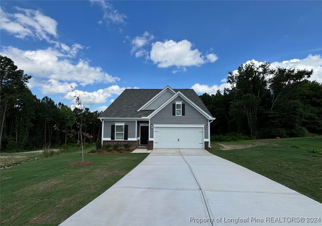 a front view of a house with a yard and trees