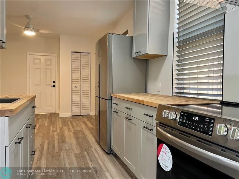 a kitchen with a stove and a wooden floor