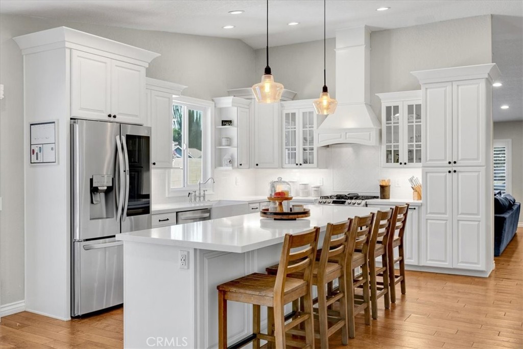 a kitchen with stainless steel appliances a dining table chairs stove and refrigerator