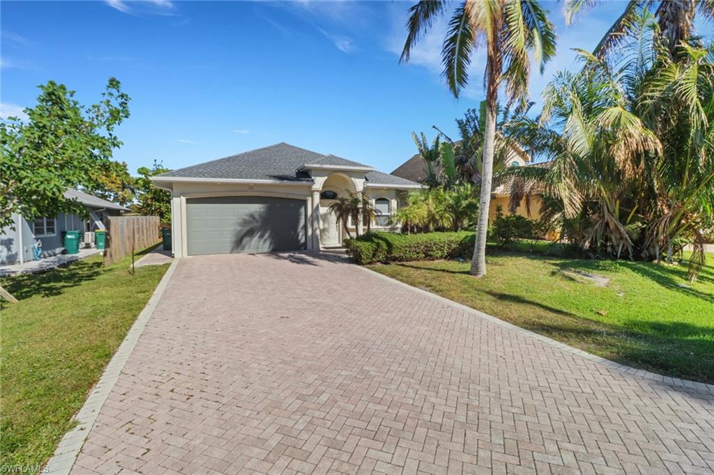 a front view of a house with a yard and trees