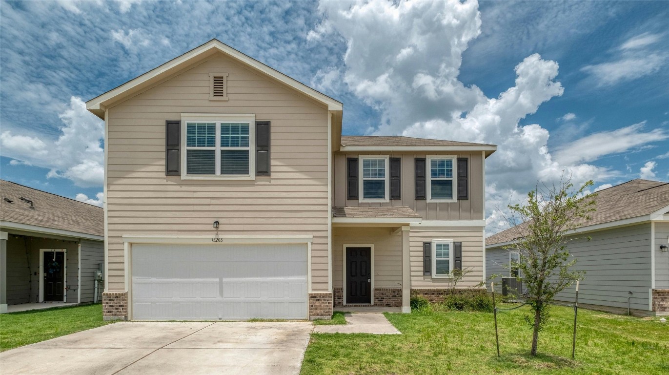 a front view of a house with a yard and garage