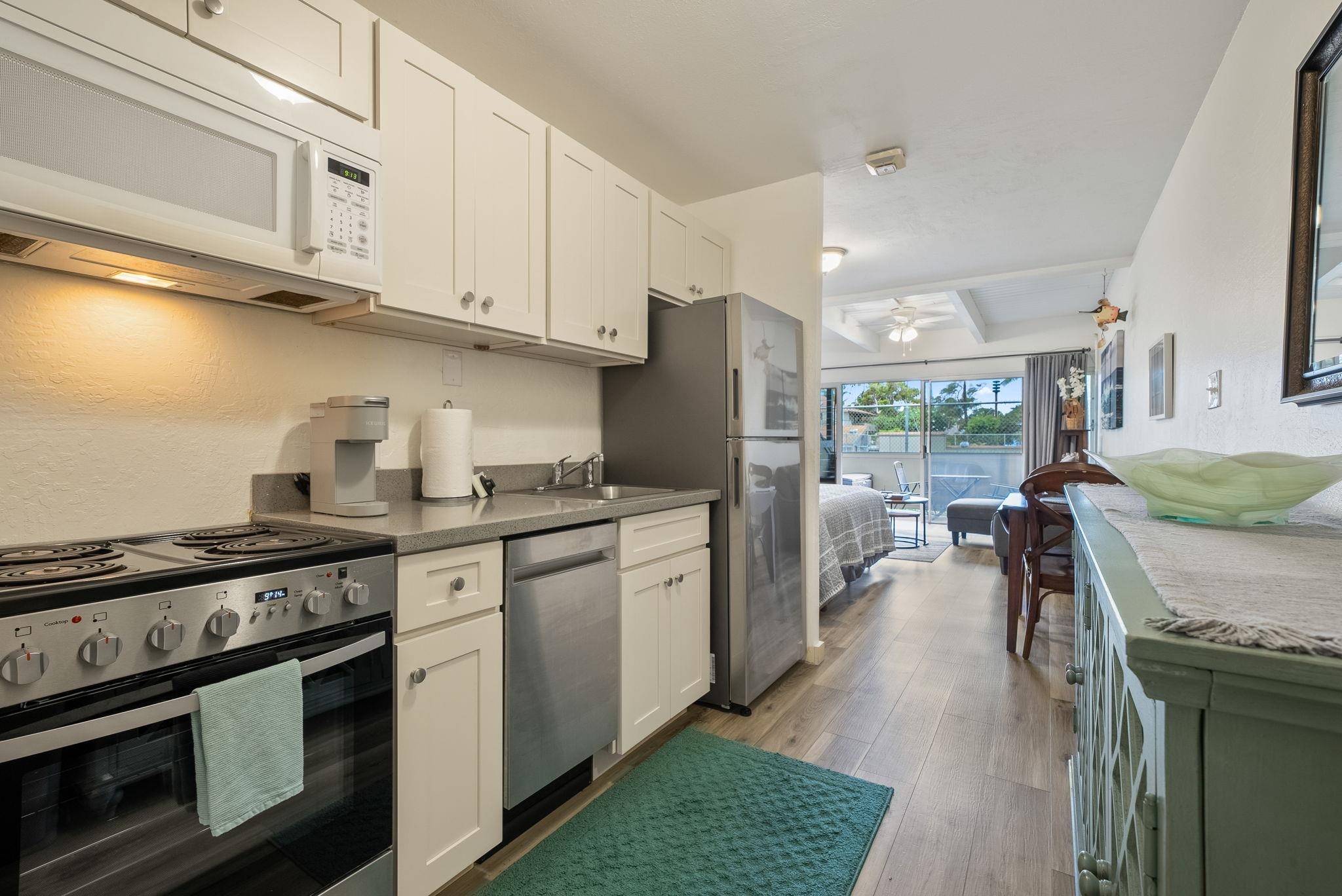 a kitchen with stainless steel appliances granite countertop a stove a sink and a refrigerator